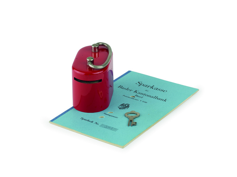 Der Besitzer dieses Sparkässeli war noch nicht einmal einjährig, als ihm seine Mutter 1937 ein Konto mit einer Einlage von 55 Franken eröffnete. Fortan zahlte sie jährlich zwischen 20 und 40 Franken ein. Das rote Kässeli, das er vom Bankhaus erhielt, sollte ihn frühzeitig das Sparen lehren. Der Bank blieb er treu. Als er 29 Jahre alt wurde, waren alle Seiten seines ersten Sparhefts gefüllt.