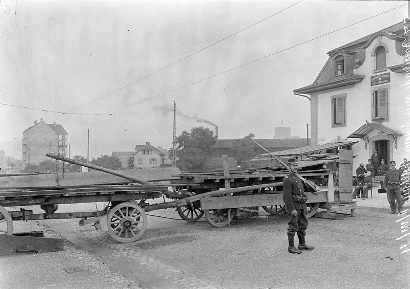 In den Wochen nach der Grenzschliessung entstanden an zehn Grenzübergängen Passierstellen mit Barrieren, militärischer Bewachung und Passkontrollhäuschen. Auch die Tramverbindung nach Hüningen und St. Ludwig wurden bei Kriegsausbruch eingestellt. Bei genauer Betrachtung sind auf dem Bild des Grenzpostens an der Hüningerstrasse, stadteinwärts fotografiert, die Tramschienen zu sehen. Der Grenzübergang ist seit 2009 geschlossen und ins Novartis-Areal integriert (Schenk, in: Basler Zeitung, 05.01.2009).