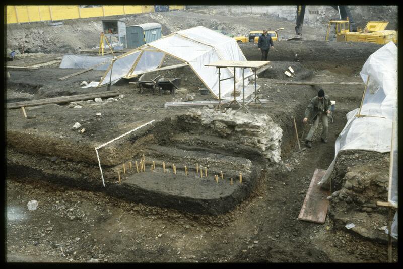 Zu den ältesten Siedlungsbefunden gehören die Überreste eines einfachen Gebäudes aus dem fortgeschrittenen 12. Jahrhundert (vgl. auch den Plan auf S. 211). Die Wände bestanden aus einer doppelten Reihe von kleinen Holzpfosten, um die Hasel- oder Weidenruten geflochten waren; als Boden diente gestampfter Lehm. Die Mauer im Hintergrund ist viel jünger; sie gehörte zu den barocken Stallungen des städtischen Fuhrparks.